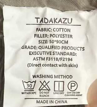 TADAKAZU Baby Loungers Recalled Due to Risk of Serious Injury or Death from Suffocation, Fall and Entrapment Hazards; Violations of Federal Standard for Infant Sleep Products; Sold on Amazon: Tag on bumpers loungers with brand name "TADAKAZU" on it, photo 1 of 4